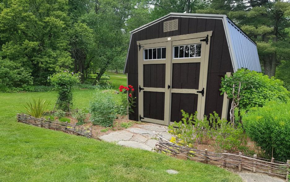 Compass Mini Barn: brown LP barn siding, double doors, tan trim and black metal roofing.